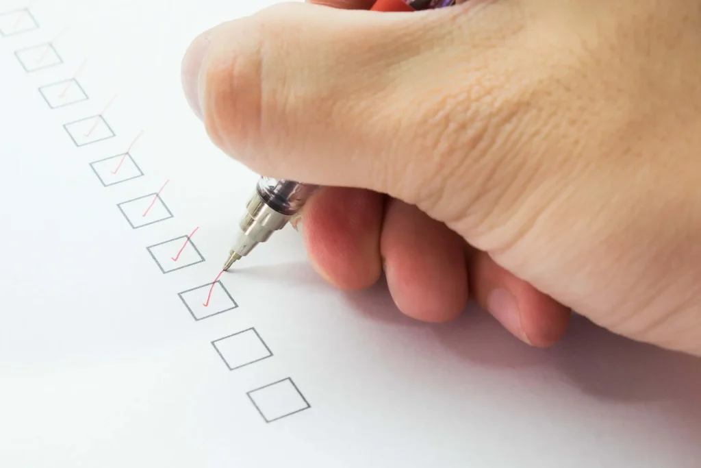 photo of a hand with a pen checking boxes