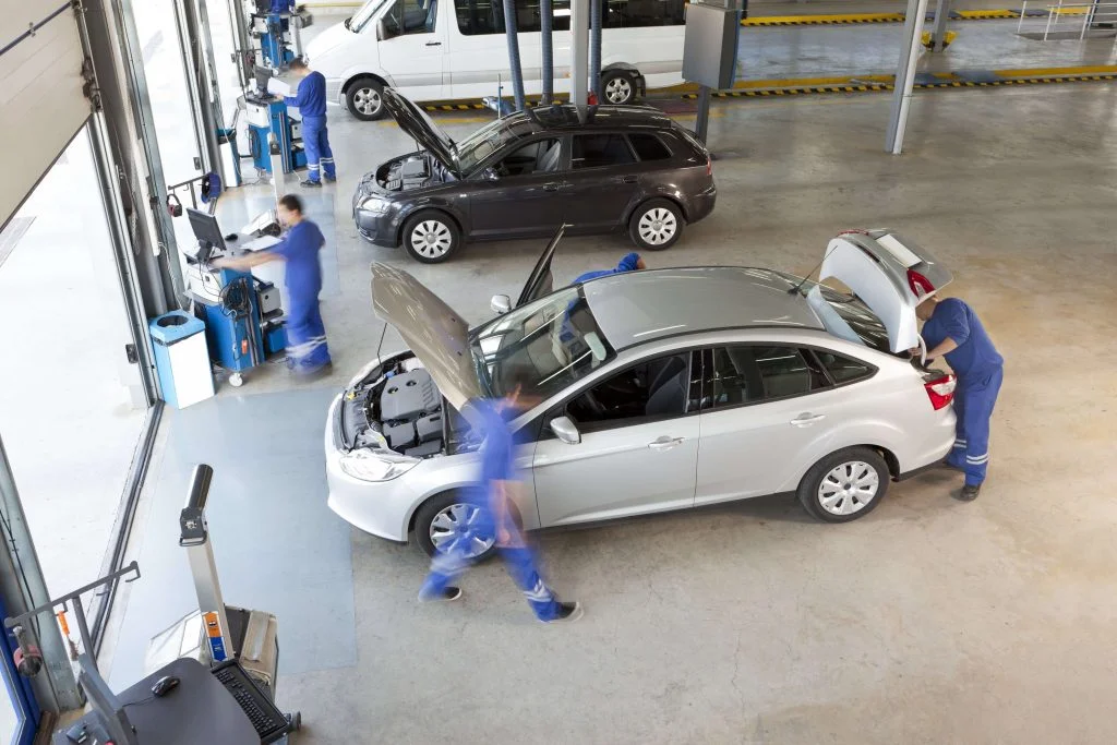 this is a photo of people working on a car and trying to repair it